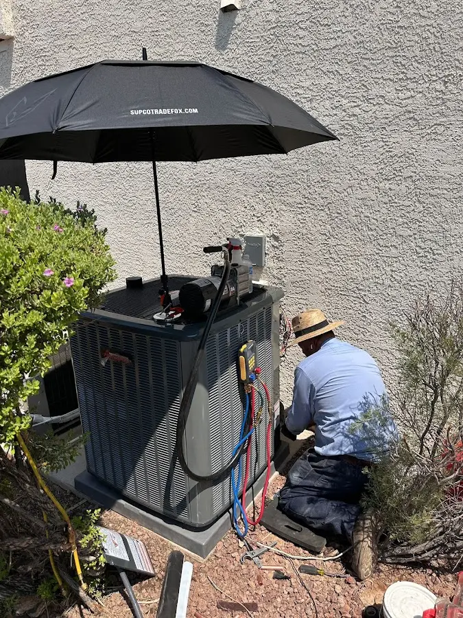 HVAC technician performing outdoor AC maintenance in Fresno